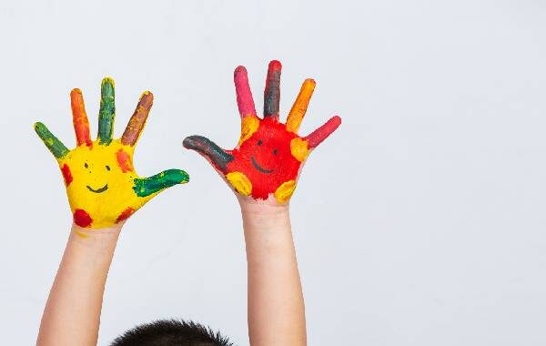 Deux mains d'enfants avec de le peinture rouge et jaune