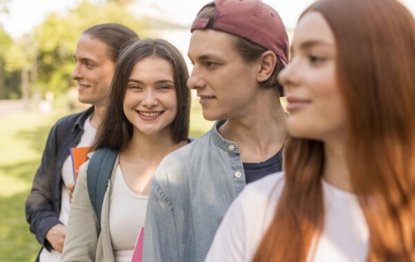 Groupe de 4 adolescents souriant, heureux regardant vers l'avenir