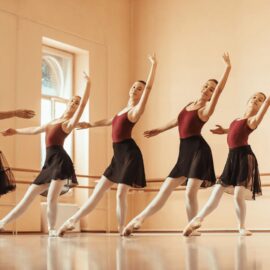 quatre jeunes filles et une enseignante pendant un cours de danse classique